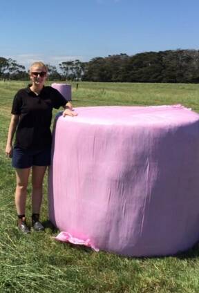 Grace Logan from Logan Contracting with one of the pink silage bales. 