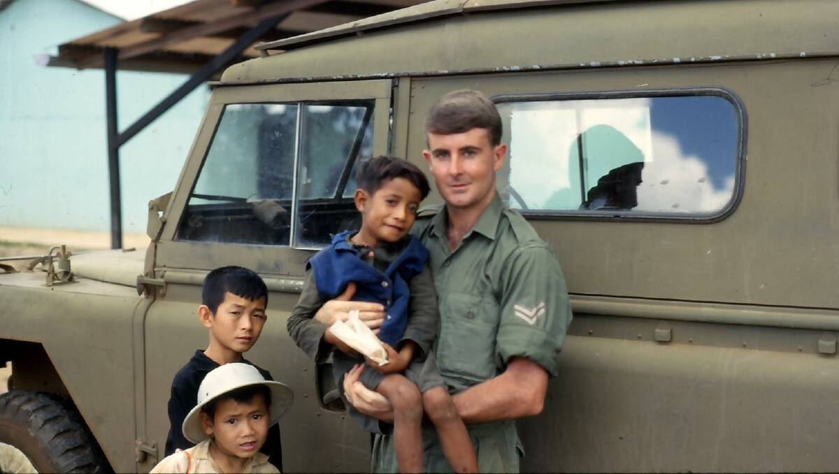 Ken Cumming holds "Rabbit," a Vietnamese boy he got to know during his time as a national serviceman in the Vietnam War.