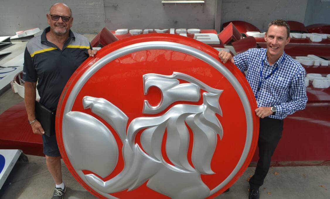 IMPRESSIVE: Warrnambool auctioneer Bruce Ludeman and Callaghan Motors dealer principal Steve Callaghan with a large Holden sign that will be up for auction on March 17. 