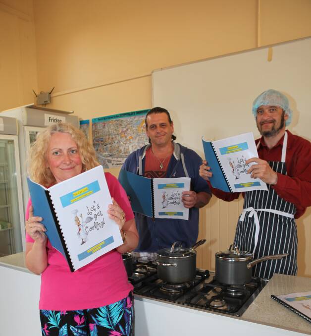 COOKING THE BOOKS: Program participant Alison Colledge with supervisor Brad Huxley and participant Jason Groves. Picture: Anthony Brady