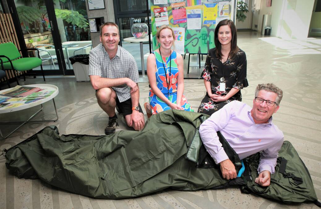 GOOD SPORT: Matt Northeast in one of the 24 donated swags with Brophy Family and Youth Services' Brendan Maher, Alana Titheridge and Tara Shannahan. Picture: Anthony Brady