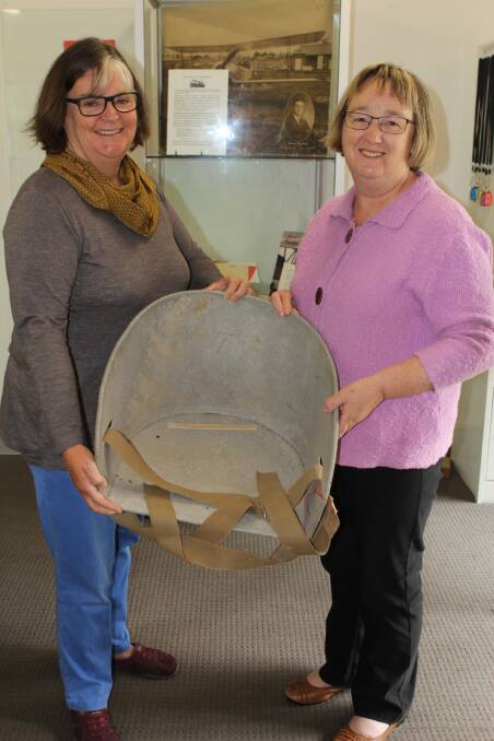 Warrnambool and District Historical Society members Janet Macdonald and Marita Murphy with the seat from Mr Basil Watson's plane. 