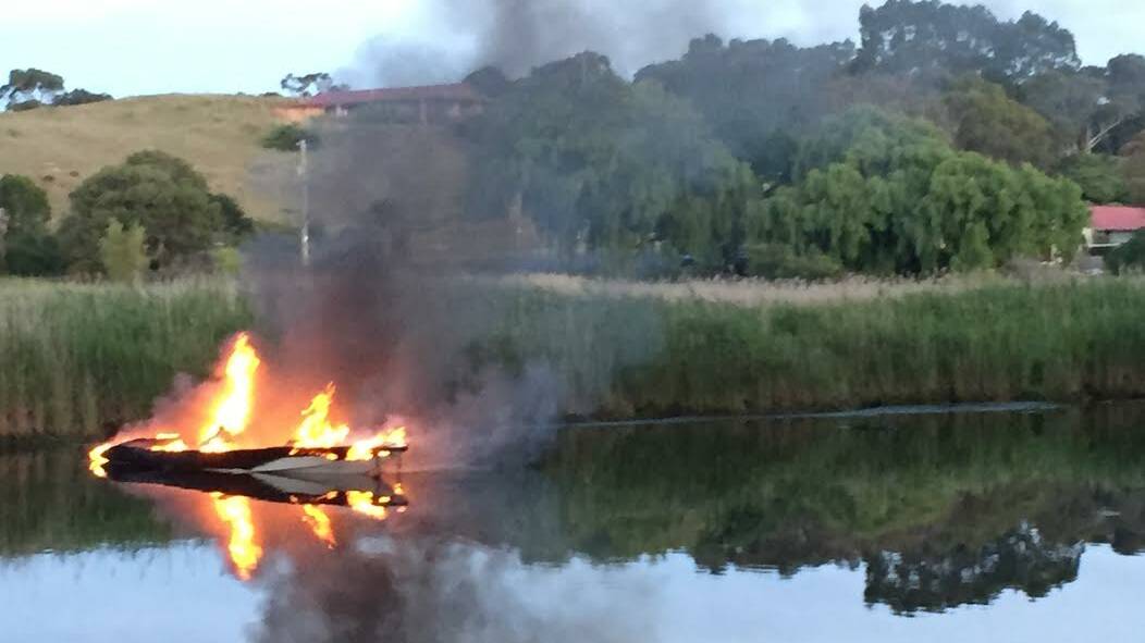 The ski boat burns on the Curdies River on Monday evening.