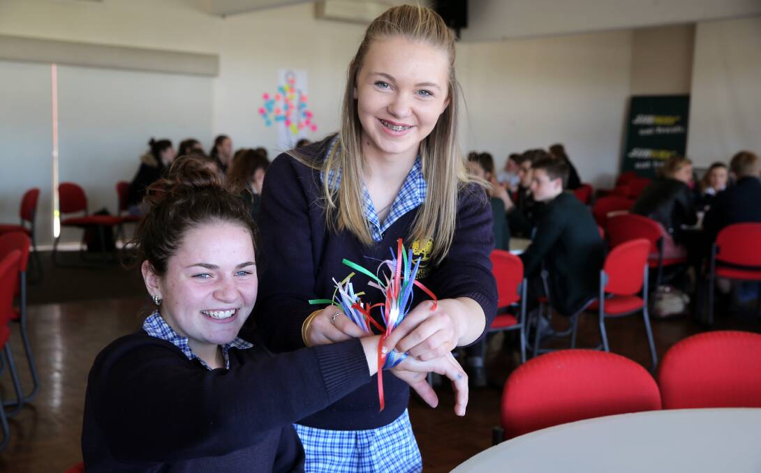 CONFIDENCE: Hawkesdale P12 College's Hayley Keane, 15, and Sarah Seabrook, 15, tie ribbons to represent positive thoughts. Picture: Rob Gunstone