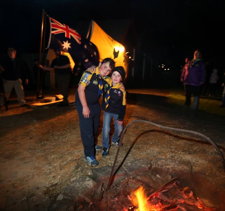CELEBRATIONS: Samuel Lukeis, 10, and Brayden McDonald, 8, both from Warrnambool Tooram Scouts, kept warm around the bonfire before the cannon firing at Flagstaff Hill. Picture: Amy Paton