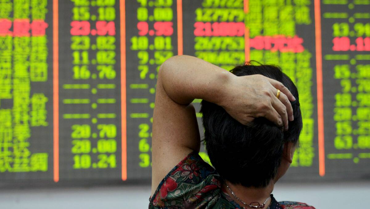 PLUNGE: An investor looks at an electronic board showing stock information at a brokerage house in Hangzhou, Zhejiang province as Chinese stocks plummeted recently.