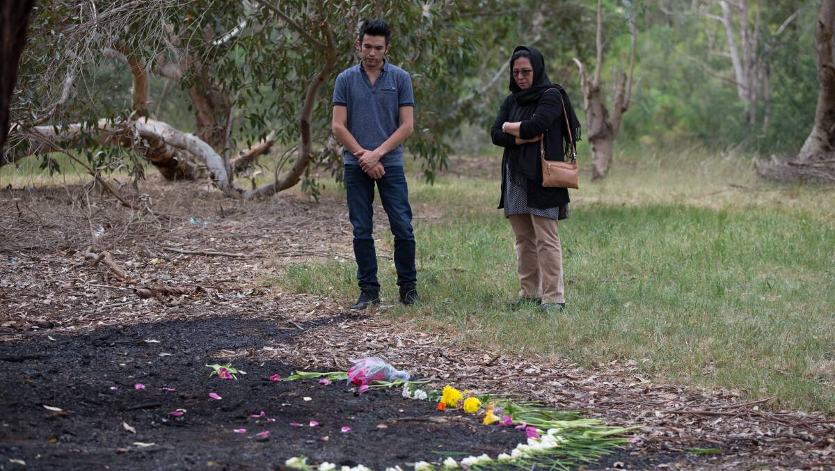 DESPAIRING: Members of the Afghan Community lay flowers at the site where Khodayar Amini self Immolated in a park in Dandenong. 