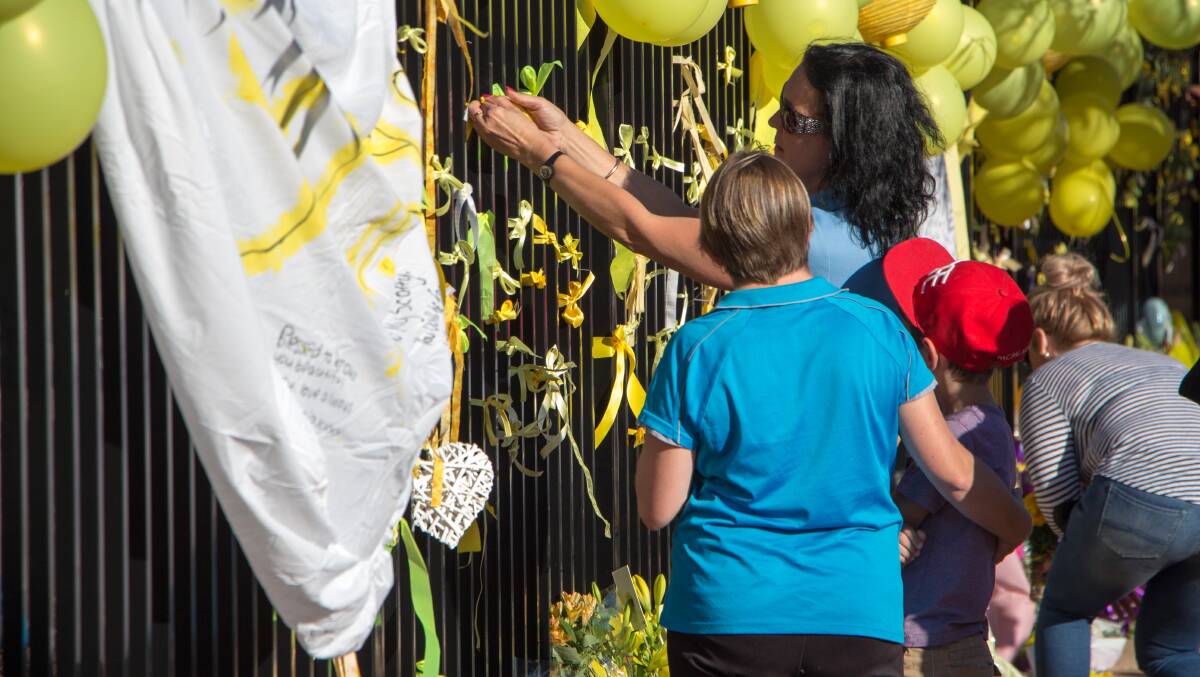 Mourners fix balloons and messages to the fence at Leeton High School as a schoolside vigil is held for Stephanie Scott. Picture: Ron Arel