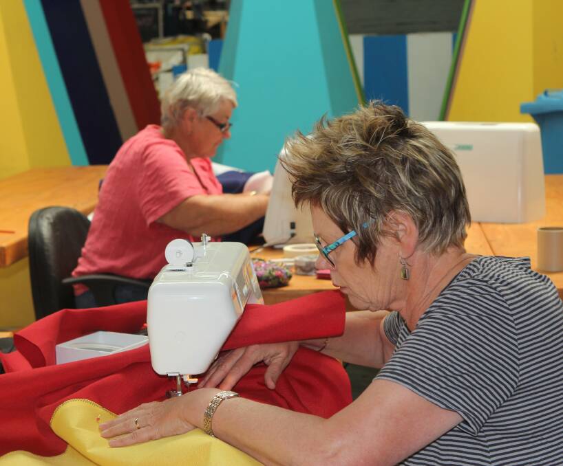 Knitting knights: Carmel Dwyer and Judy Roberts from the Port Fairy Ladies Craft Group have been sewing 40 flags for the 40th annual Port Fairy Folk Festival next month. Picture: Steff Wills 