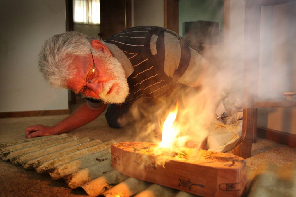 Aboriginal elder Rob Lowe conducts a smoking ceremony in a house in an attempt to drive out bad spirits in 2008.