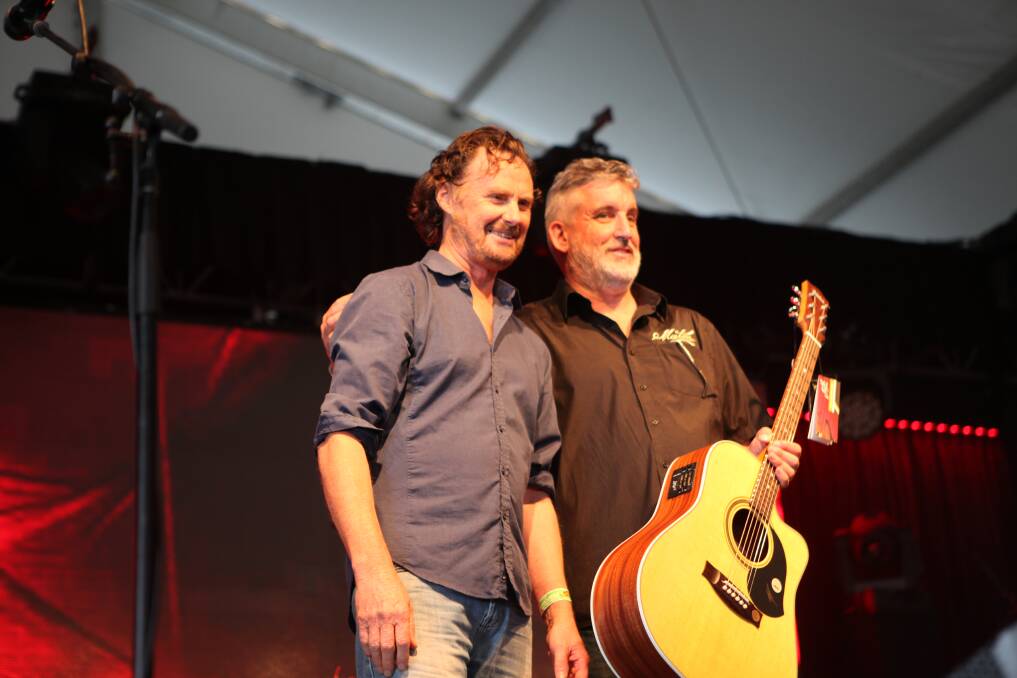 Pat Evans (right) from Maton Guitars presents Neil Murray with his prize.