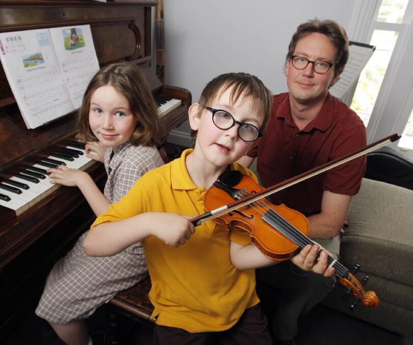 CHILD'S PLAY: WSO violinist Tris Forster (right) listens as his children Felix Buchanan, 8, and Archie Buchanan, 5, perform. Picture: Rob Gunstone