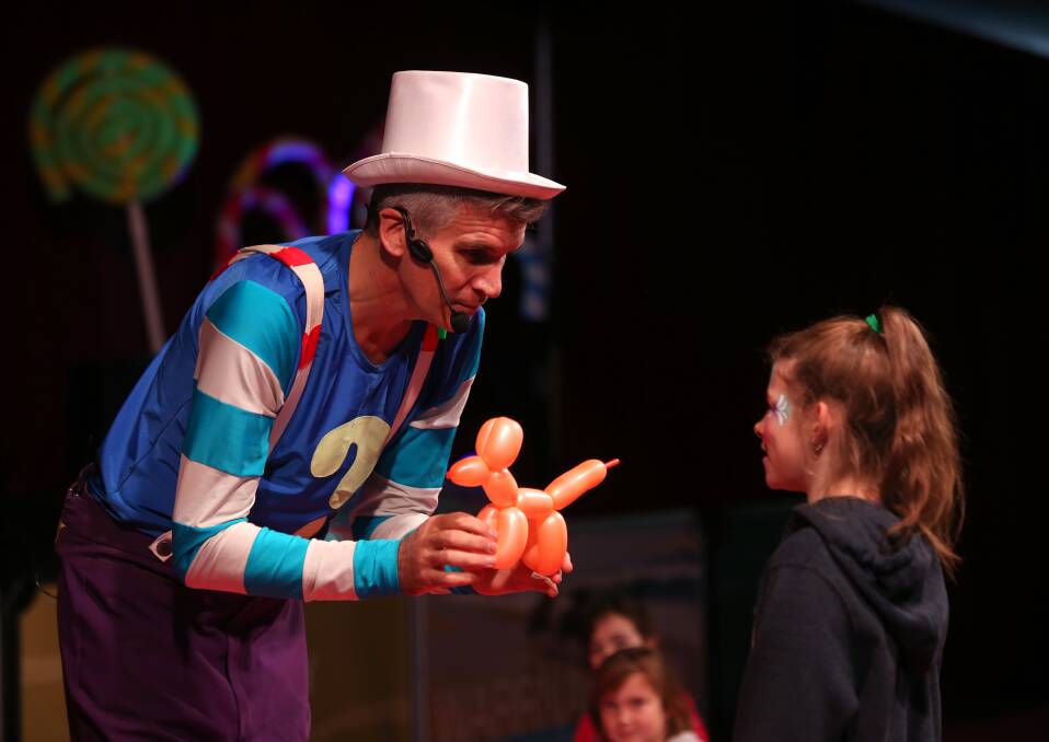 THE TRICKSTER: Chris from The Kazoos entertained crowds during the day, presenting children like Alaska with balloon creations. Picture: Amy Paton