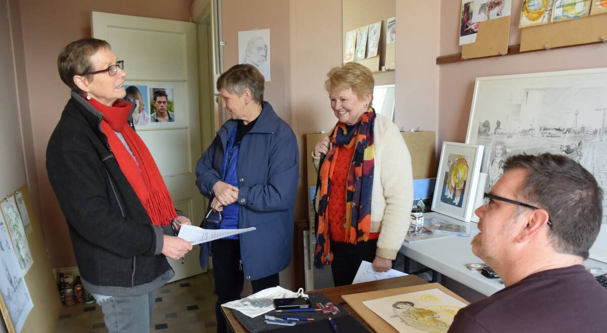 ART ATTACK: (from left) Joy Knight, Denise Wood and Yvonne Stewart check out Phillip Cooke's art in his studio at The Artery. Picture: Matt Neal