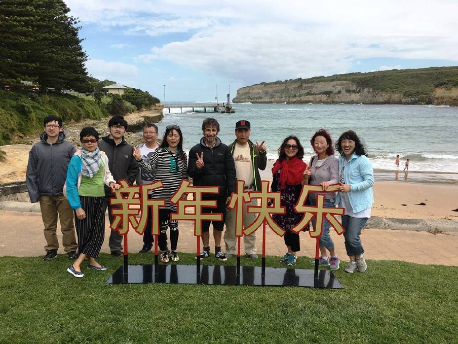 Port Campbell Visitor Information Centre manager Mark Cuthell with Chinese visitors during the 2017 Chinese New Year celebrations. 