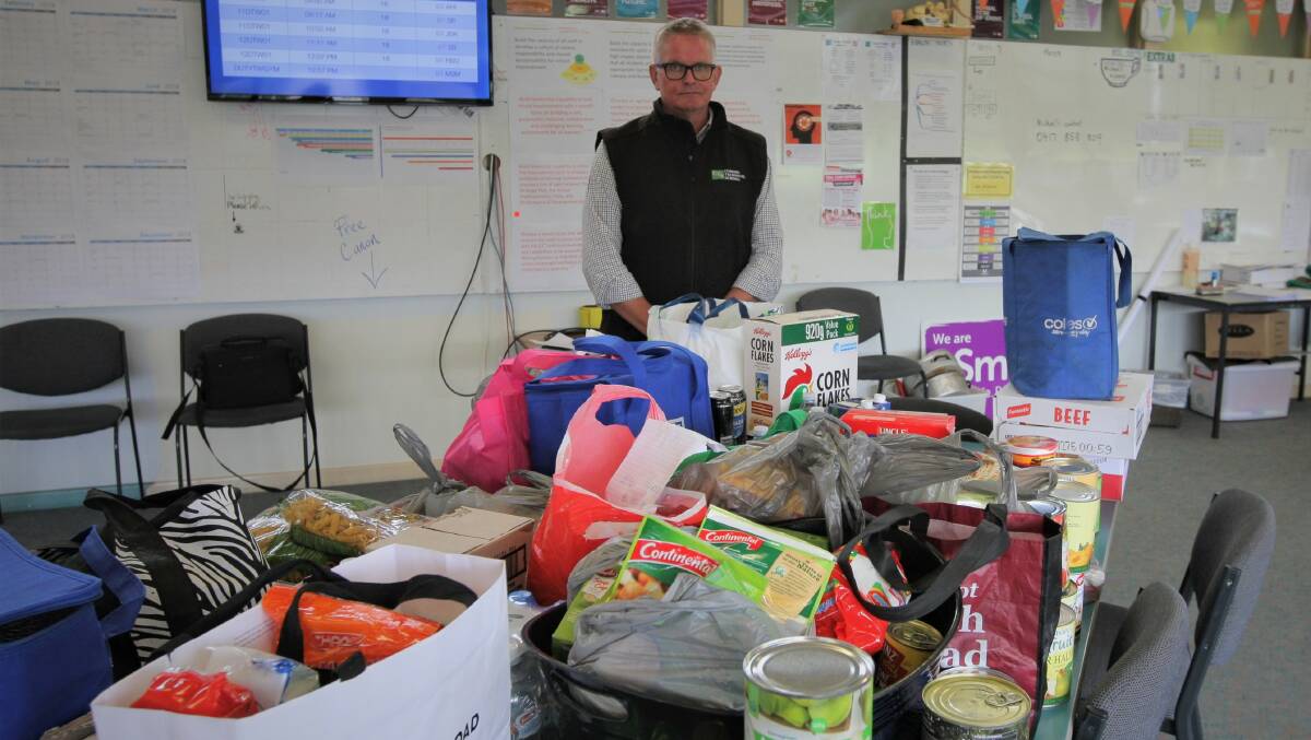Recovery: Cobden Technical School principal Rohan Keert with a table of food donated by Warrnambool College staff that will be distributed to school community families in need. 