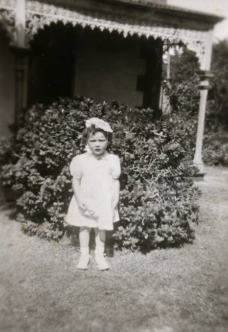Rosemary Moore as a young girl standing outside what was the family home located on the hospital grounds.