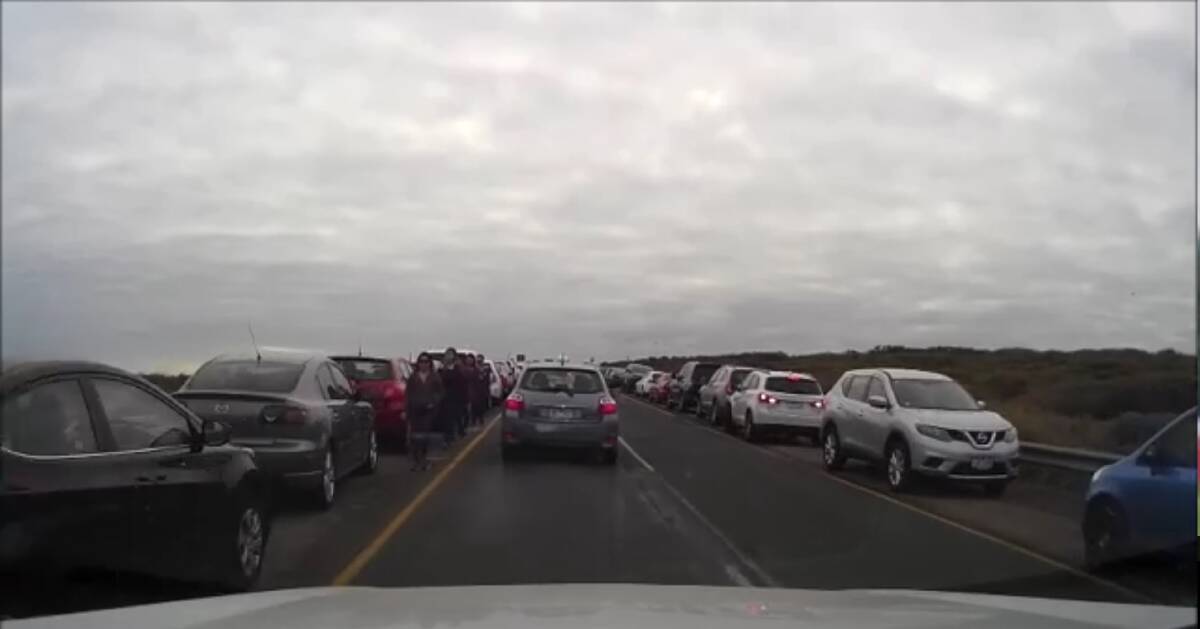 Under pressure: A dashcam image of the Great Ocean Road over the Easter weekend showing cars and people lining the road.
