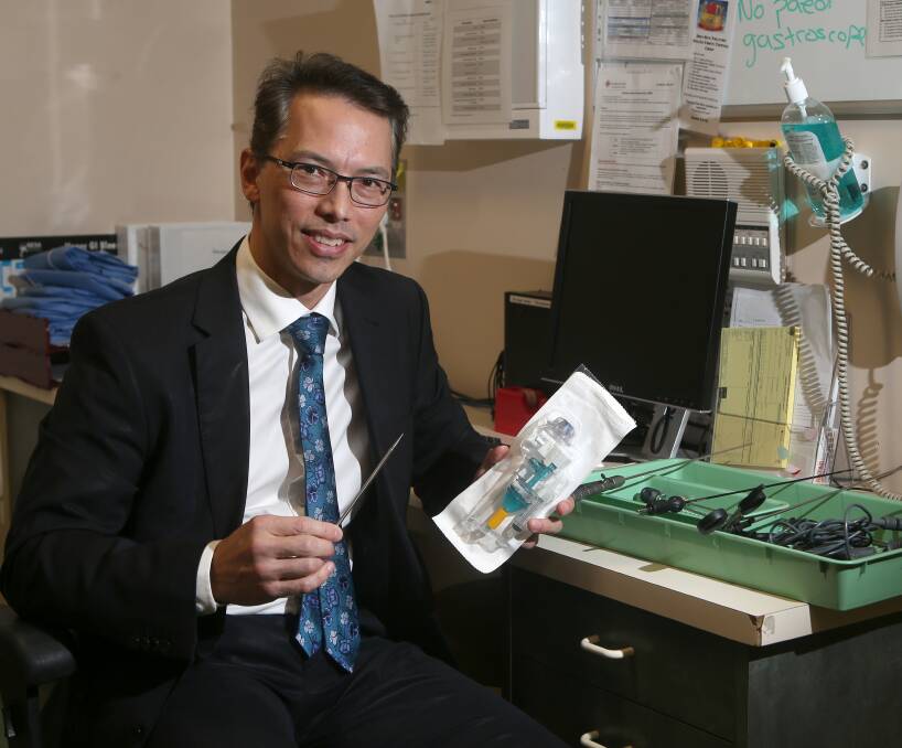 Nation first: Surgeon Philip Gan is using a new model of mini-laparoscopic instruments. He's holding one of the new instruments in his right hand, compared to the larger, older equipment in his left. Picture: Amy Paton