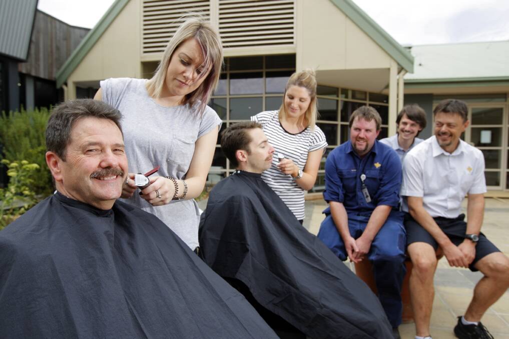 Hairdressers Kim Hiensch and Elle Dwyer, from Men Only Hair Design, gets to work on St John of God Warrnambool chief Trevor Matheson and Adrian Benson as Brad Smith, John Oxford and Mark Powell wait their turn. Picture: Rob Gunstone