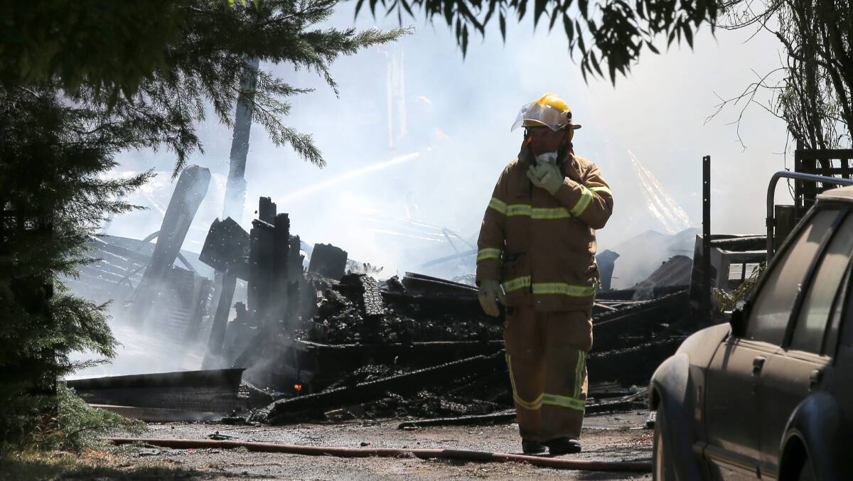 FIRE: CFA officers work to cool the remains of a house that burnt down in Hawksdale. Picture: Rob Gunstone