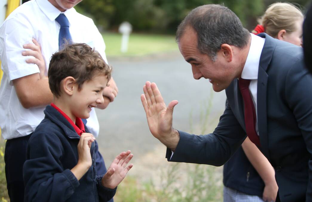 HIGH FIVE: Warrnambool Special Developmental School's Max Darmanin, 6, celebrates with Education Minister James Merlino at the school's new site. Picture: Amy Paton. 