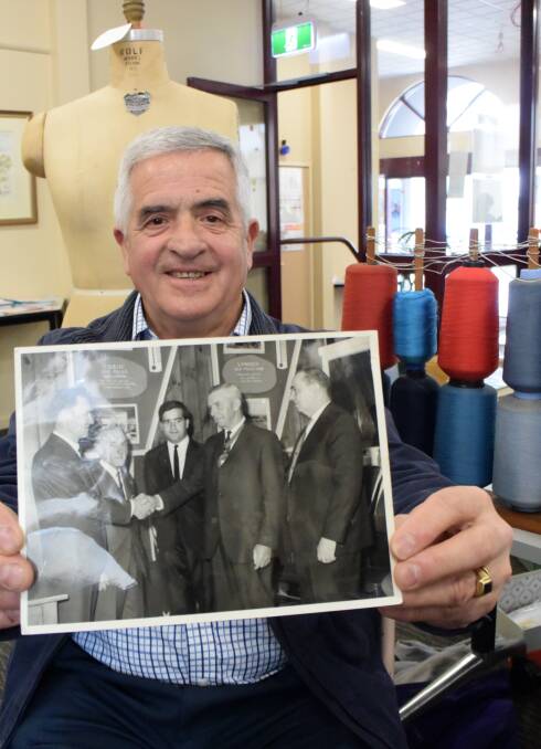 MEMORIES: Gae Remine holds a photo, with Mr Remine in the centre, from when he was made an Australian citizen in a cermony in the Fletcher Jones canteen.