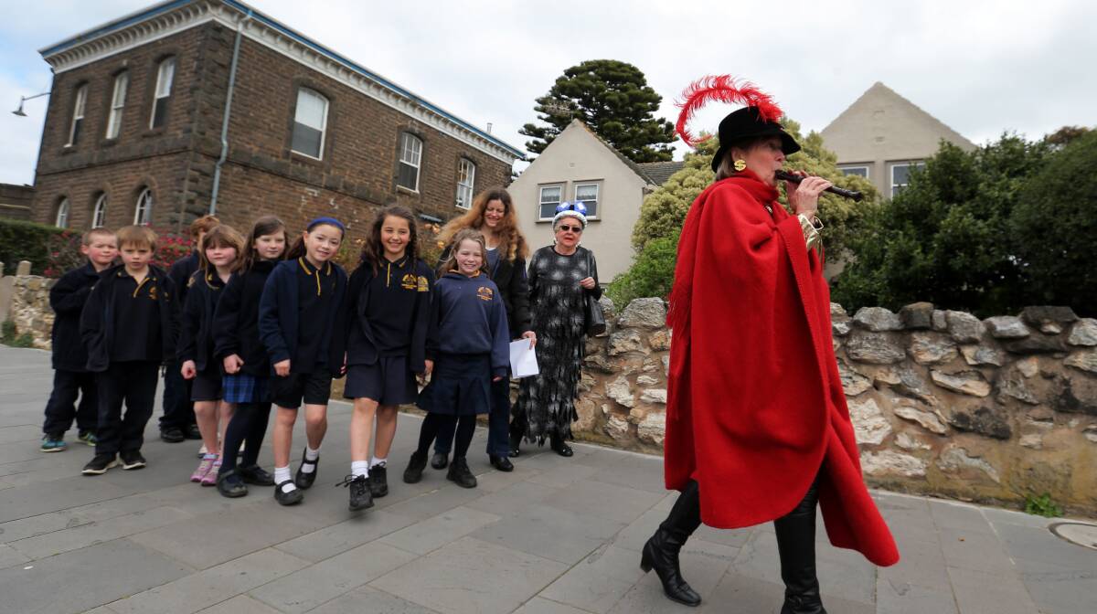 Ex Libris president Kath Harper walks a group of Port Fairy Consolidated School pupils along Sackville Street, before reading them a story. Picture Rob Gunstone.

