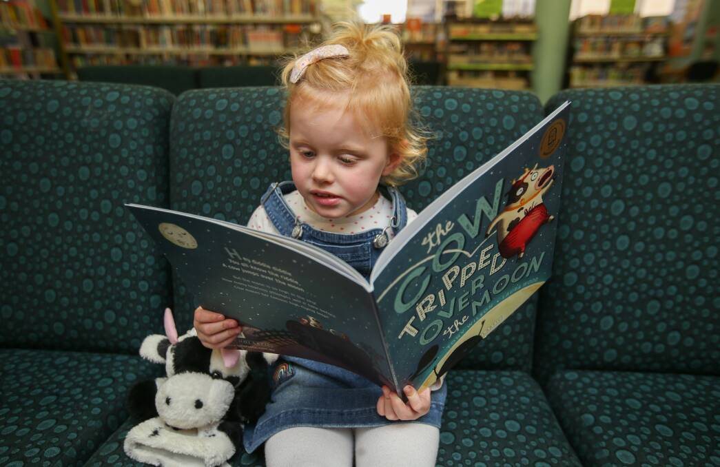 Tall tale: Warrnambool's Audrey Sheldon, 3, reads The Cow Tripped Over The Moon, ahead of Wednesday's National Simultaneous Storytime event. Picture: Amy Paton