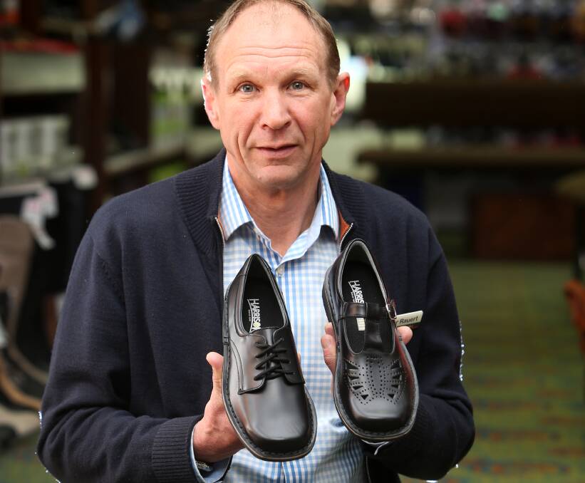 Safety first: Rauerts Shoex owner Peter Rauert demonstrates the difference between a girls' lace-up school shoe and a T-bar shoe. T-bars will be banned from Emmanuel College from next year. Picture: Amy Paton