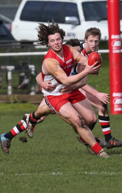 PRESSURE: South Warrnambool midfielder Sam Thompson is tackled by Koroit's Taylor Mulraney as Saint defender Dallas Mooney watches on. Picture: Vicky Hughson