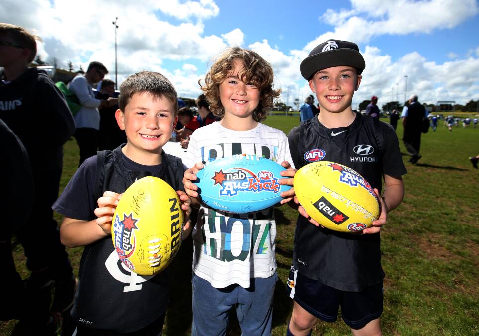 WE ARE THE NAVY BLUES: Carlton fans Zeke, 6, Beau, 8, and Isaac Williams, 10, of Warrnambool, show off their autographs from the AFL players.