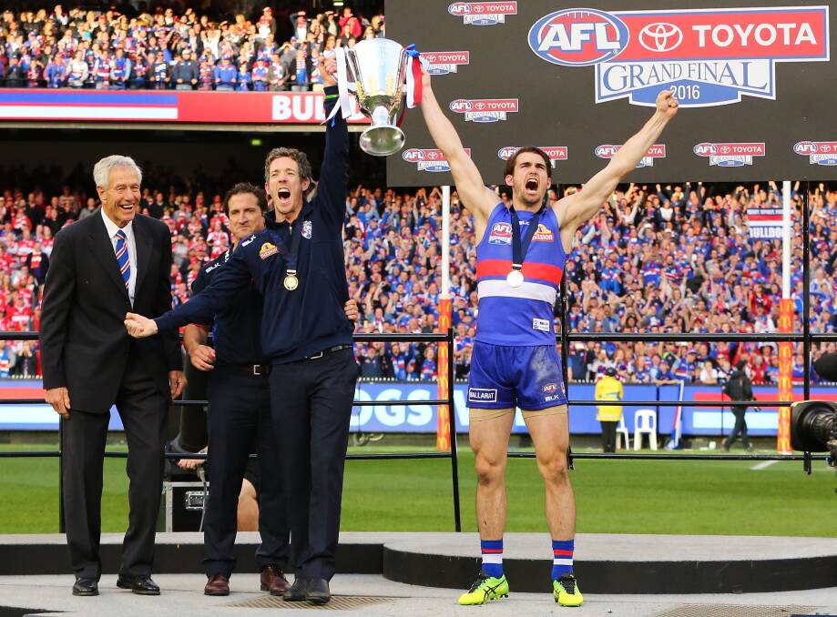 ICONIC MOMENT: Injured Western Bulldogs captain Bob Murphy lifts the premiership cup with stand-in leader Easton Wood. Picture: Getty Images