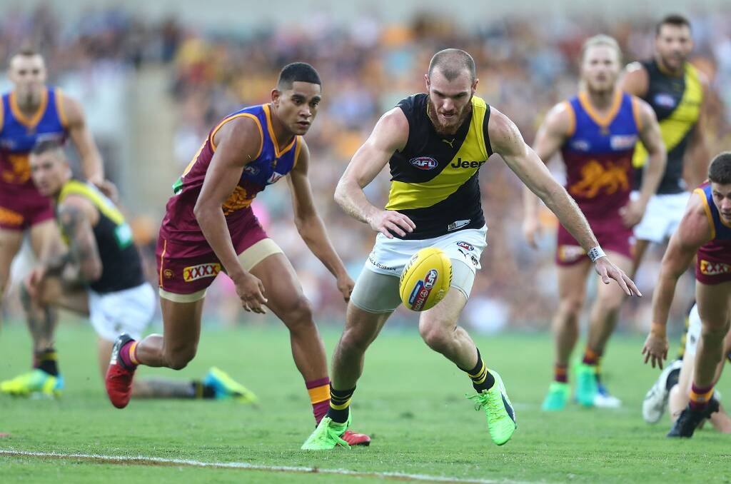 BIG STAGE: Brisbane first-gamer Cedric Cox battles Richmond's Kamdyn McIntosh in the Lions' loss at the GABBA on Sunday. Picture: Getty Images