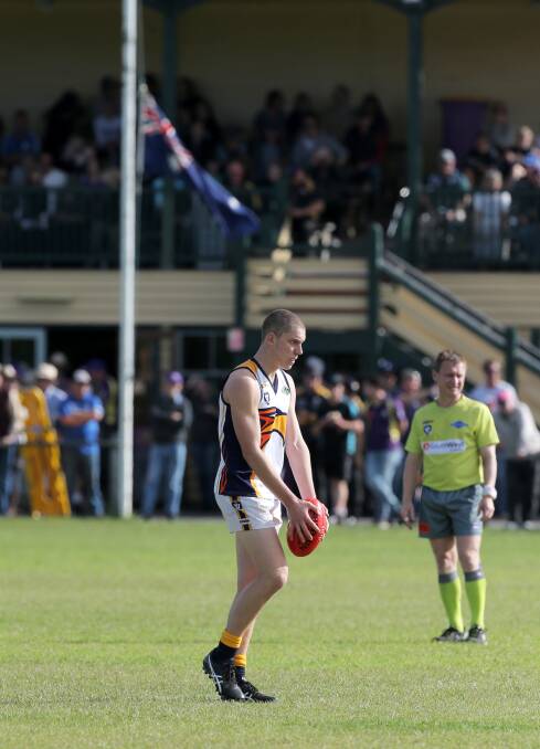 LEST WE FORGET: The Australian flag flies at half mast to honour the Anzacs as North Warrnambool Eagles forward Josh Corbett lines up for goal. Picture: Rob Gunstone