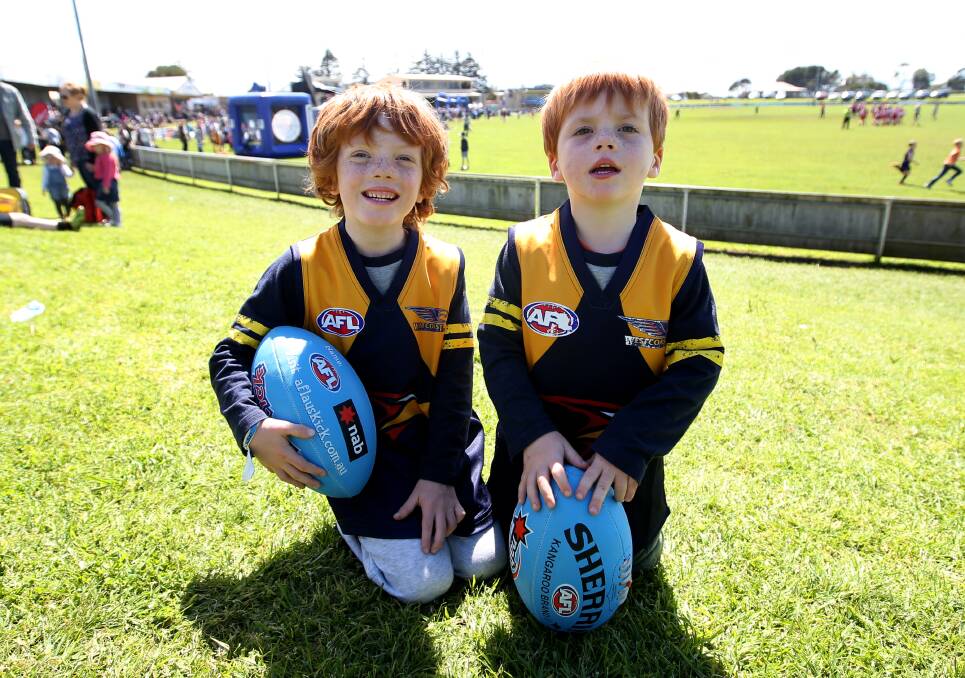 BROTHERS IN ARMS: Young fans Roy Savage, 5, and brother Nico, 4, with their free footballs at Reid Oval on Friday.