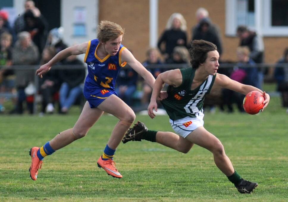 CATCH ME IF YOU CAN: Hampden's Alex Lavithis-Davis bounds away from Wimmera opponent Cooper Heard in Ararat on Wednesday.