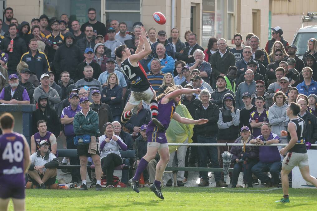 BIG CROWD, BIG MOMENT: Koroit high-flyer Jeremy Hausler uses Port Fairy ruckman James Vickers as a launching pad as a bumper grand final crowd watches on. Picture: Rob Ginstone 