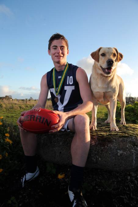 Terang Mortlake's Scott Carlin was part of the Victorian 15 and under football squad which claimed national championship honours. He is pictured with two-year-old golden retriever Simba. Picture: Rob Gunstone