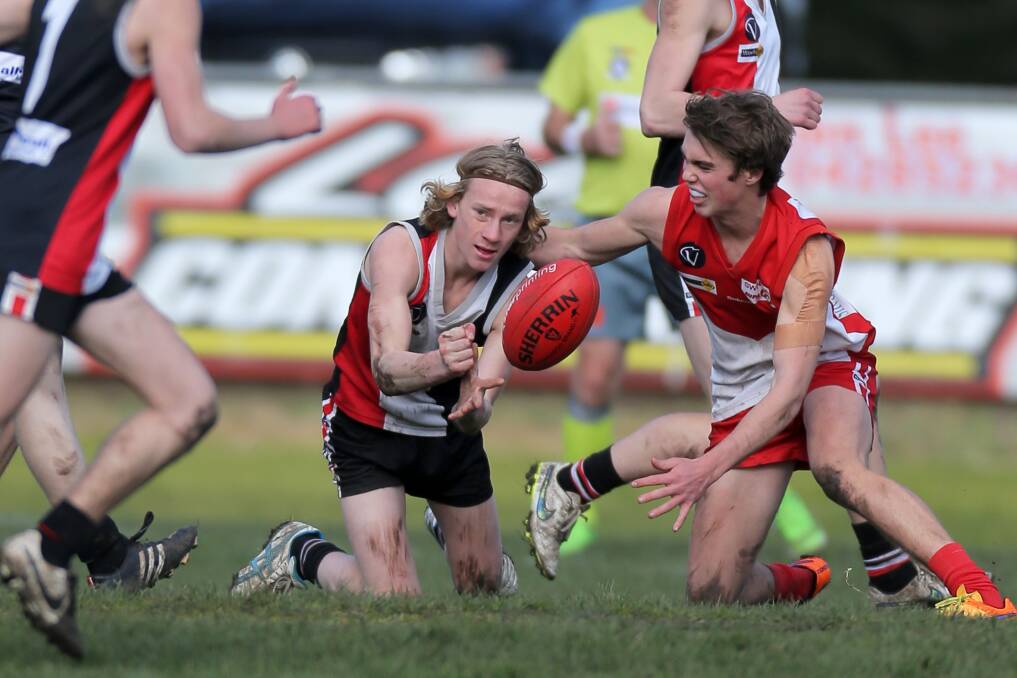 Koroit's Angus Campbell fires out a handball under pressure from South Warrnambool's Sam Lee during the Hampden league under 16 qualifying final. League officials are taking the grand final to Camperdown's Leura Oval on Sunday. Picture: Rob Gunstone