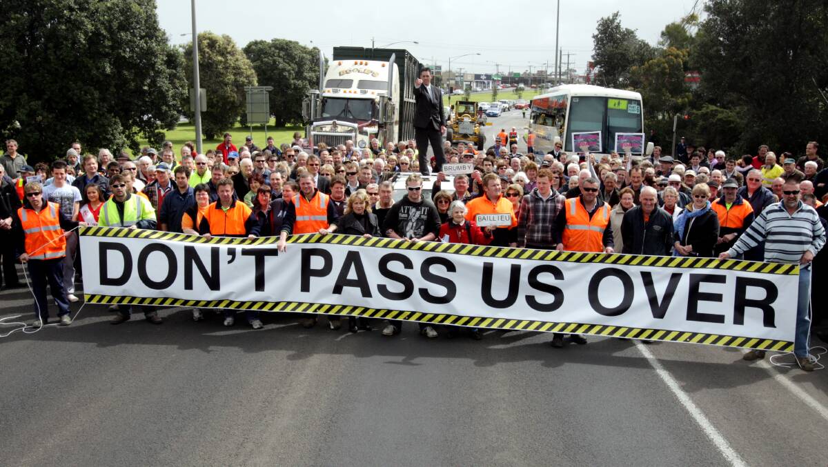 Flashback: September 2010. Then Warrnambool mayor Michael Neoh stands on a crashed car as part of the Don't Pass Us Over rally held in a bid to win greater funding for the Princes Highway. The rally shut down the city's major thoroughfare.