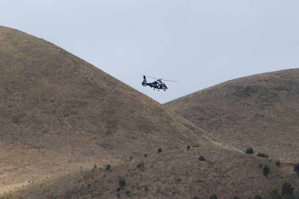 A police helicopter flies over Mt Elephant at Derrinallum in the wake of the explosion that killed Glenn Sanders.