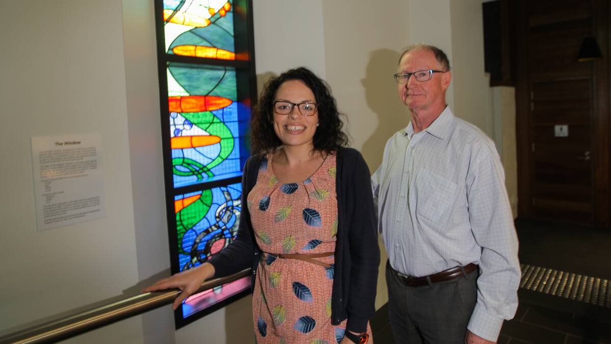 Adding light: Donna Monaghan and Father John Fitizgerald at a leadlight window that is one of the new centre's many attractive features. 