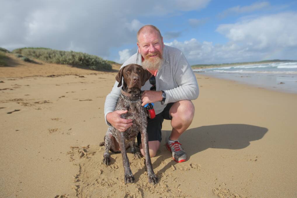 Paws versus jaws: Stephen Mitchell posing alongside Ziggy, who attempted to jump on a small shark in Warnambool on Wednesday. Picture: Morgan Hancock