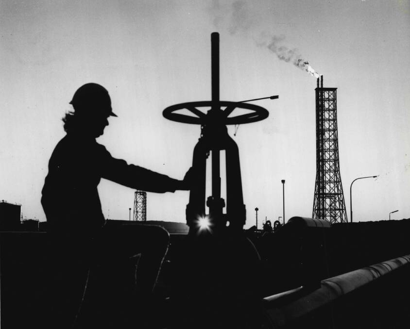 A worker makes adjustments at an onshore gas treatment plant.