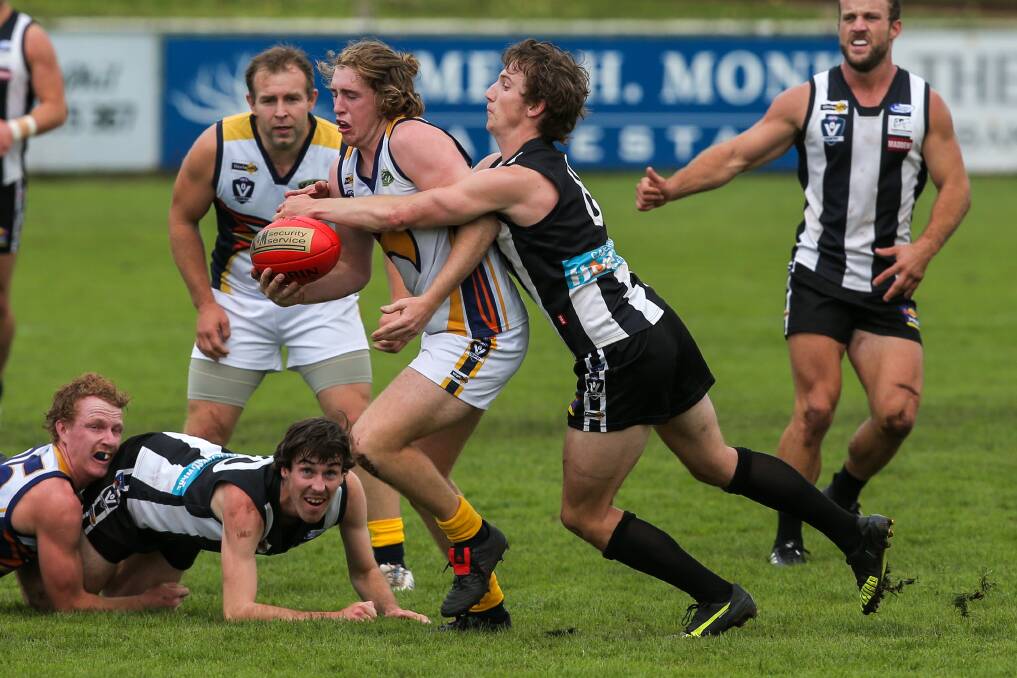 FEELING THE HEAT: North Warrnambool Eagles' Louis Kew is tackled by Camperdown's Cam Spence. Picture: Rob Gunstone