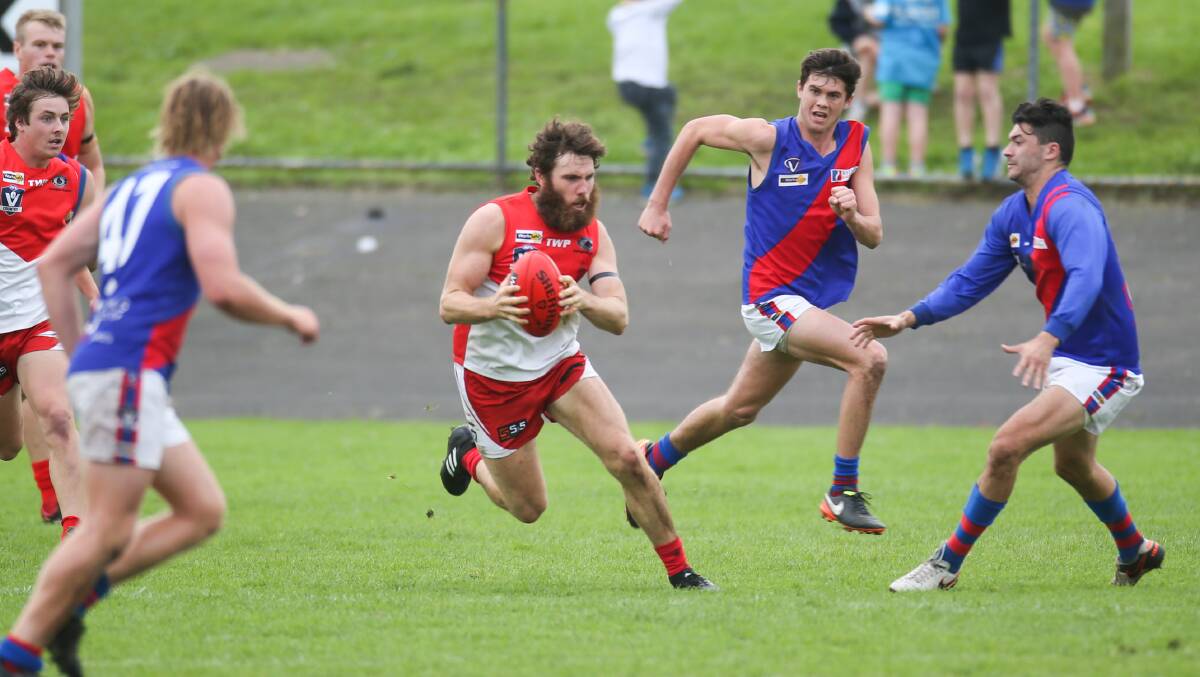 FINDING SPACE: South Warrnambool's James Hussey breaks through with the ball as Terang Mortlake players close in. Picture: Morgan Hancock