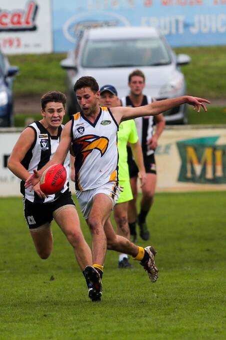 RETURN: North Warrnambool Eagles' Tim O'Brien drives the ball through the centre of the ground in his first senior footy match in more than a year. Picture: Rob Gunstone