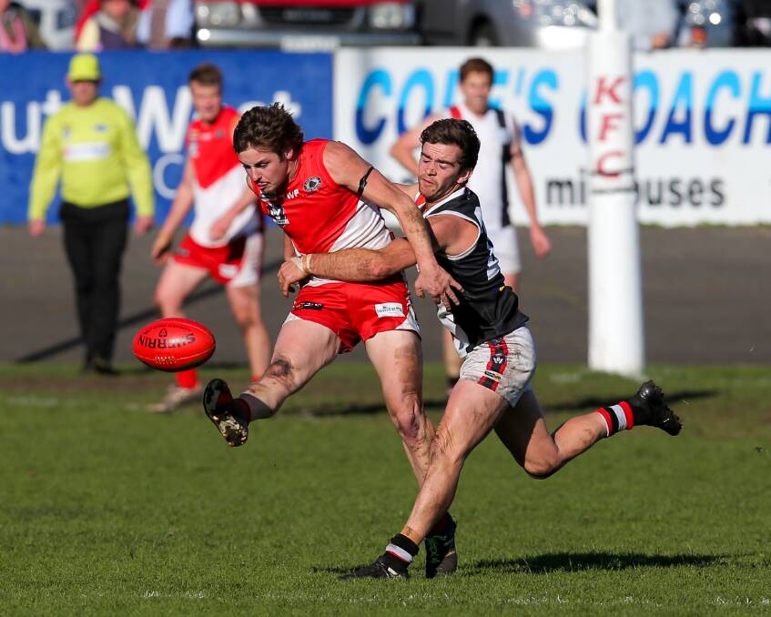 Good Friday rivals: South Warrnambool's Ben Thornton gets a kick away as he is tackled by Koroit's James North during the 2017 season. They will face off in a Good Friday showdown next year. Picture: Rob Gunstone