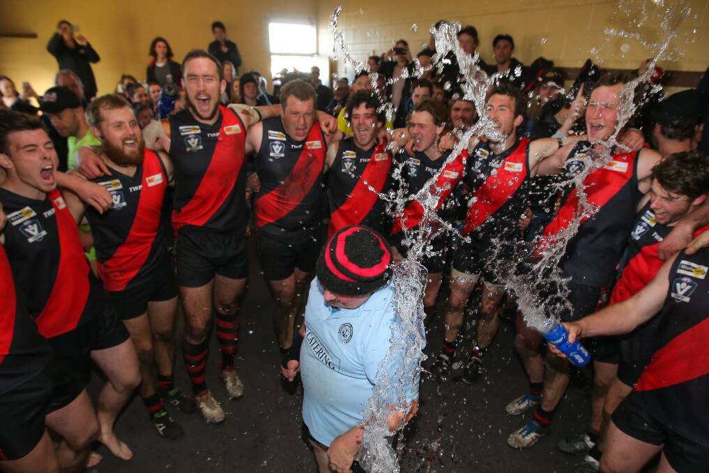 SEASON ALIVE: Cobden players spray Stewie Pearson, who celebrated his 200th game as water carrier, while they sing the song following their first semi-final win against South Warrnambool. Picture: Morgan Hancock